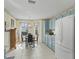 Bright kitchen features blue cabinets, white appliances, and tile floors, perfect for cooking at 17860 Se 89Th Natchez Ave, The Villages, FL 32162