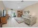 Bright living room features neutral tile flooring, ceiling fan, and sliding glass doors leading to an outdoor patio at 17860 Se 89Th Natchez Ave, The Villages, FL 32162