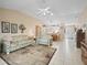 Spacious living room featuring neutral tile flooring which extends to dining area, light walls and furniture at 17860 Se 89Th Natchez Ave, The Villages, FL 32162