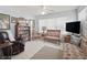 Comfortable seating area with tile floors, a bookshelf, and a large window with window coverings at 17860 Se 89Th Natchez Ave, The Villages, FL 32162