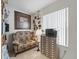 Cozy office space featuring a patterned couch, a printer, and natural light from a large window at 17860 Se 89Th Natchez Ave, The Villages, FL 32162