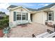 Charming front patio area featuring brick pavers, comfortable seating, and a quaint, cozy atmosphere at 17860 Se 89Th Natchez Ave, The Villages, FL 32162