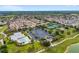 An aerial view showcasing the community clubhouse, pool, tennis courts, and parking area at 2101 Southern Star Way, The Villages, FL 32162