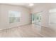 This light-filled bedroom features a ceiling fan, sliding glass doors to the porch, and wood flooring at 2101 Southern Star Way, The Villages, FL 32162
