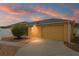 Home at sunset with a well manicured lawn, beautiful shrub, and a two car garage at 2101 Southern Star Way, The Villages, FL 32162
