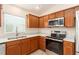 Kitchen featuring stainless steel appliances, wood cabinets, granite countertops, and a stainless steel sink at 2101 Southern Star Way, The Villages, FL 32162