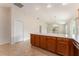 Kitchen breakfast bar is surrounded by tile floors, has wood cabinets and overlooks the living area and sliding glass doors at 2101 Southern Star Way, The Villages, FL 32162