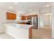 The kitchen features wood cabinetry, stainless appliances, a breakfast bar, and modern lighting fixtures at 2101 Southern Star Way, The Villages, FL 32162