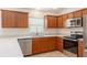 Kitchen featuring a breakfast bar, wood cabinets, stainless steel appliances, and granite countertops at 2101 Southern Star Way, The Villages, FL 32162