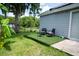 Spacious backyard with an artificial turf patio area with chairs, offering a peaceful spot by a large tree at 2110 Churchill Downs Cir, Orlando, FL 32825
