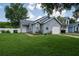 Inviting single-story home with attached garage, complemented by lush lawn and mature landscaping at 2110 Churchill Downs Cir, Orlando, FL 32825