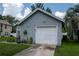 Attached garage of gray single-story home with a well-maintained lawn and colorful flower bed at 2110 Churchill Downs Cir, Orlando, FL 32825