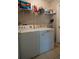The laundry room featuring a washer, dryer, and shelving for efficient organization at 2110 Churchill Downs Cir, Orlando, FL 32825