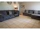 Bright living room with tiled floors, a decorative wall, and comfortable gray couches at 2110 Churchill Downs Cir, Orlando, FL 32825