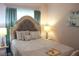 Cozy bedroom with a large decorative headboard, matching lamps and curtains, and calm colors at 2112 Waitman, Leesburg, FL 34748