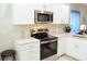 Well-equipped kitchen with stainless steel appliances, white cabinets, and modern finishes at 2112 Waitman, Leesburg, FL 34748