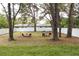 Spacious backyard featuring mature trees, a white fence, and outdoor seating areas at 2114 Waitman Ave Waitman, Leesburg, FL 34748