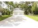 Two-story home with a two-car garage and a long driveway, surrounded by mature trees at 2114 Waitman Ave Waitman, Leesburg, FL 34748