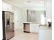 Open-concept kitchen featuring stainless steel appliances, white cabinetry, and tile flooring at 2114 Waitman Ave Waitman, Leesburg, FL 34748