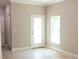 Neutral-toned living room with a decorative glass front door and tiled flooring at 2114 Waitman Ave Waitman, Leesburg, FL 34748