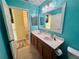 Bright bathroom featuring double vanity, tile floor, and blue walls at 2122 Waseca Ln, Leesburg, FL 34748
