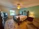 Cozy bedroom with decorative metal headboard, ceiling fan, and natural light at 2122 Waseca Ln, Leesburg, FL 34748