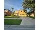 Charming two-story home featuring a bright yellow exterior, well-kept lawn, and a spacious driveway at 2122 Waseca Ln, Leesburg, FL 34748