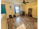 Living room featuring wood-look flooring, a ceiling fan, and natural light at 2122 Waseca Ln, Leesburg, FL 34748