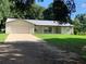 Charming single-story home with a metal roof, large front yard, and an attached two-car garage at 2530 Shady Ln, Groveland, FL 34736
