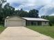Charming single-story home with a metal roof, two-car garage, and a concrete driveway at 2530 Shady Ln, Groveland, FL 34736