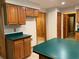 Kitchen space with wood cabinets, a green countertop, tile flooring, and wood-paneled walls at 2530 Shady Ln, Groveland, FL 34736