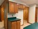 Kitchen space with wood cabinets, a green countertop, tile flooring, and wood-paneled walls at 2530 Shady Ln, Groveland, FL 34736
