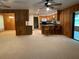 Open living and kitchen area with tile floors and wood-paneled walls at 2530 Shady Ln, Groveland, FL 34736