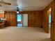 Spacious living room with wood paneling, carpeted floors, and a sliding glass door to a porch at 2530 Shady Ln, Groveland, FL 34736