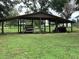 Open shed with a car and tractor offering ample storage for equipment and vehicles at 2530 Shady Ln, Groveland, FL 34736