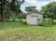 Outdoor shed features a roll-up door, providing secure and convenient storage space at 2530 Shady Ln, Groveland, FL 34736