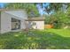 Exterior view of the backyard with sliding glass doors, green grass, and partial fencing at 2708 Lorraine Dr, Leesburg, FL 34748