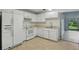 Bright kitchen featuring white appliances, tile flooring and backyard access at 2708 Lorraine Dr, Leesburg, FL 34748