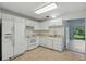Well-lit kitchen with white appliances and plentiful cabinet space for storage at 2708 Lorraine Dr, Leesburg, FL 34748