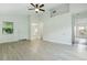 Spacious living room with a ceiling fan, light wood-look floors and abundant natural light at 2708 Lorraine Dr, Leesburg, FL 34748