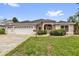 Charming single-story home with a three-car garage and well-manicured lawn and landscaped bushes at 2881 Manor Downs, The Villages, FL 32162