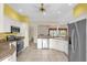 Bright kitchen with stainless steel appliances, white cabinets, and tile flooring at 2881 Manor Downs, The Villages, FL 32162