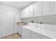 Functional laundry room with cabinets and modern washer and dryer at 2881 Manor Downs, The Villages, FL 32162