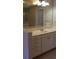 Bathroom vanity with sink and countertop, complemented by cabinets for storage and a large, well-lit mirror at 31104 Fairvista Dr, Tavares, FL 32778