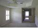 Large bedroom features a tray ceiling, neutral paint colors and a view to the bathroom at 31104 Fairvista Dr, Tavares, FL 32778