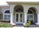 Elegant arched entryway with double doors and manicured landscaping accents at 31104 Fairvista Dr, Tavares, FL 32778