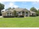 Charming single-story home featuring a well-manicured lawn and arched entryway at 31104 Fairvista Dr, Tavares, FL 32778