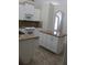 Open kitchen with an island, granite countertops, white cabinets, and modern appliances at 31104 Fairvista Dr, Tavares, FL 32778