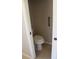Compact toilet tucked in a small area, featuring safety bar and light tile flooring for functionality and accessibility at 31104 Fairvista Dr, Tavares, FL 32778