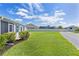 Well-manicured lawn and landscaping in a spacious backyard with a white fence for privacy at 3283 Dawn Pl, The Villages, FL 32163